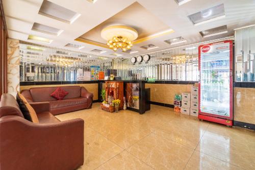 a waiting room with a couch and a refrigerator at Collection O Long Phung Hotel in Ho Chi Minh City