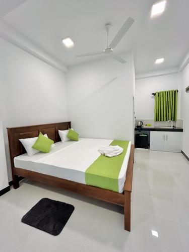 a bedroom with a large bed with green pillows at Rufero Transit Hotel in Katunayaka