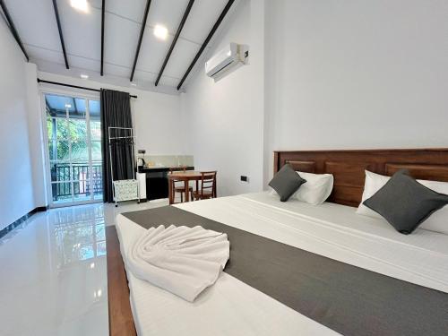 a bedroom with a large bed and a table at Rufero Transit Hotel in Katunayaka