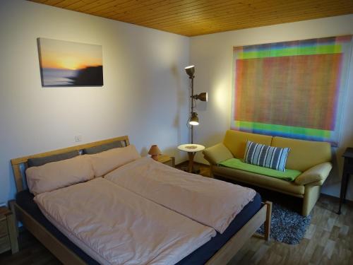 a bedroom with a bed and a couch and a window at Bio Bed & Breakfast Froschkönig in Gersau