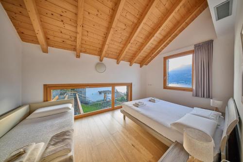 a bedroom with two beds and a large window at Paradiso del lago in Bellano
