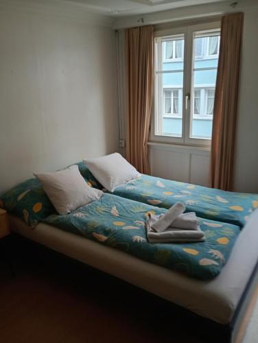 a bed with towels on it with a window at Central tiny studio in St. Gallen