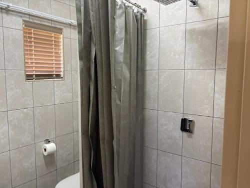 a bathroom with a shower with a shower curtain at Witgatboom Boskamp in Naboomspruit