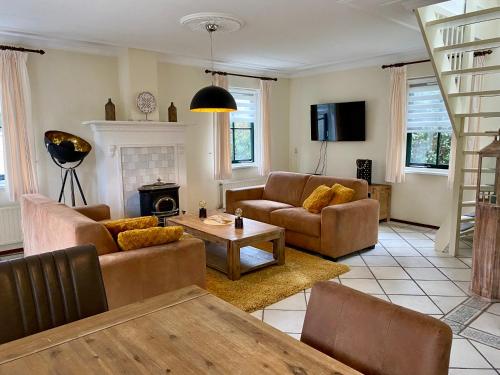 a living room with two couches and a table at Buitenplaats 67 with optional sauna in Callantsoog