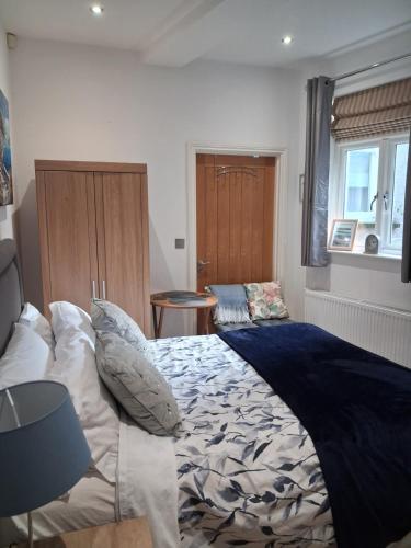 a bedroom with a bed and a table and a window at BODLONDEB CASTLE BED & BREAKFAST { CENTRAL LLANDUDNO} in Llandudno
