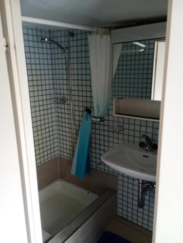 a bathroom with a bath tub and a sink at Central tiny studio in St. Gallen
