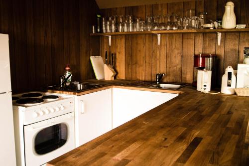 a kitchen with a white stove and a wooden floor at Old Cottage - Reynivellir II in Gerdi