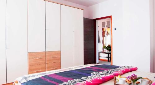 a bedroom with a large bed with white cabinets at Apartman Šestine in Zagreb