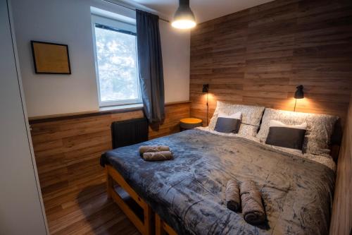 a bedroom with a large bed with a wooden wall at Apartmán Tady 67 in Dolní Moravice