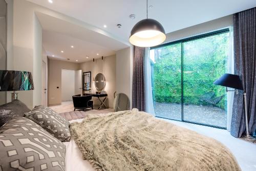 a bedroom with a bed and a large window at Luxurious subterranean mansion - 3 spectacular bedrooms in Altrincham