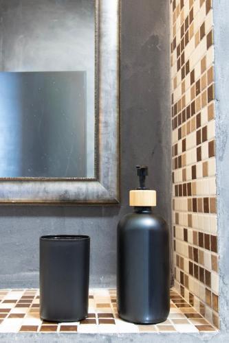 a black bottle sitting next to a trash can in a bathroom at Apartmán Tady 67 in Dolní Moravice