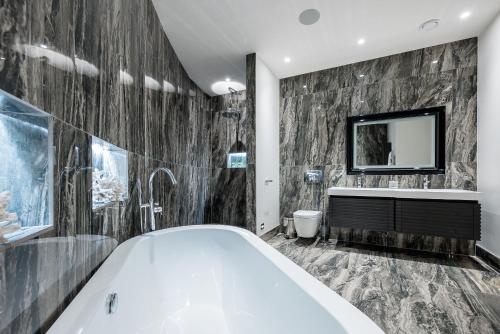 a bathroom with a tub and a tv on the wall at Luxurious subterranean mansion - 3 spectacular bedrooms in Altrincham