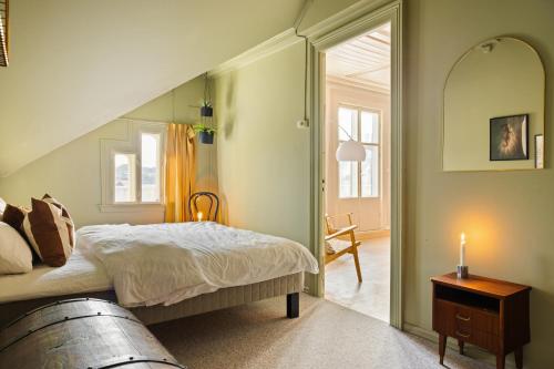 a bedroom with a bed and a staircase with a candle at VILLA BRATTHOLMEN in Brattholmen