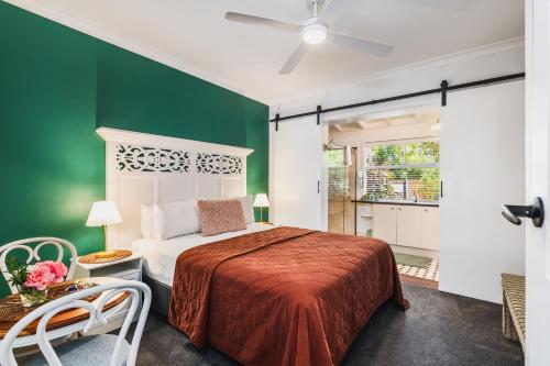 a bedroom with a bed and a green wall at Rosewood Guesthouse in Margaret River Town