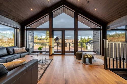 a living room with a couch and large windows at Idre Himmelfjäll Resort in Idre