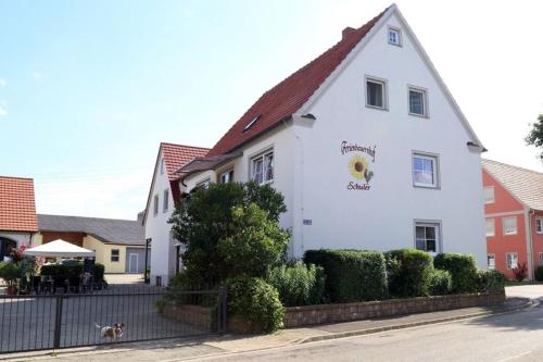 a white building with a dog in front of it at Ferienbauernhof Schuler in Gunzenhausen