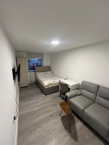 a living room with a couch and a bed at Private Studio by Wembley in Preston