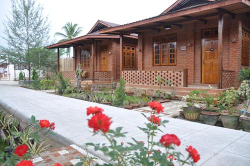 a house with red flowers in front of it at Trinity Family Inn in Nyaung Shwe