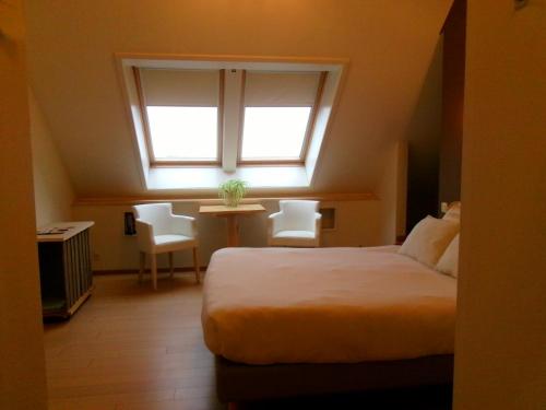 a bedroom with a large bed and a window at b&b Kraaiberg in Ploegsteert