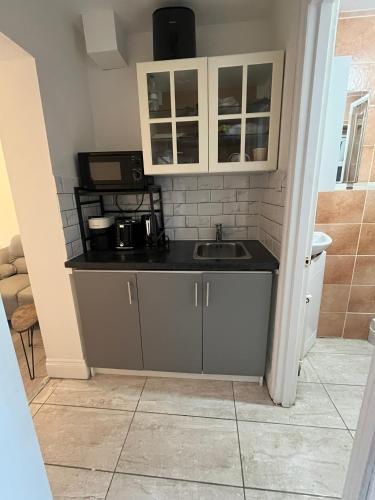 a kitchen with a sink and a microwave at Private Studio by Wembley in Preston