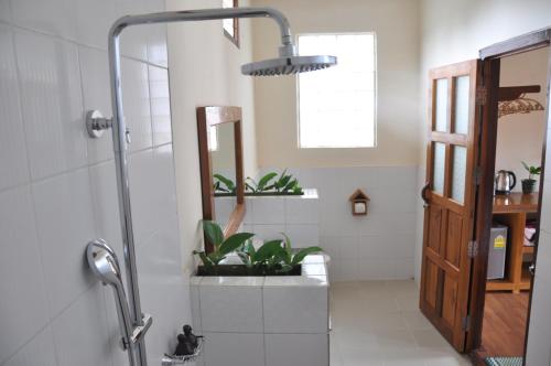 een badkamer met een douche met planten bij Trinity Family Inn in Nyaung Shwe