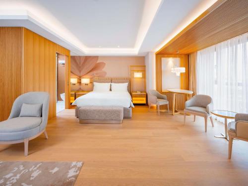 a hotel room with a bed and chairs at Mövenpick Hotel Istanbul Bosphorus in Istanbul