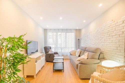 a living room with a couch and a brick wall at Espacioso y cómodo apartamento en Pamplona in Barañáin