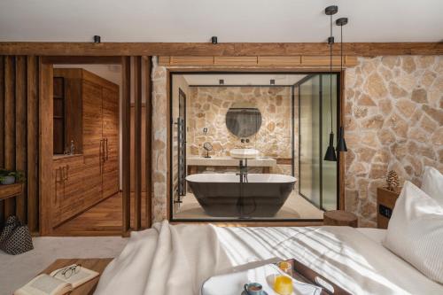 a bathroom with a tub and a large mirror at Flora Boutique Hotel in Borovets