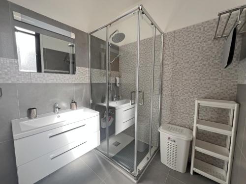 a bathroom with a sink and a glass shower at Albert's apartments in Larnaca