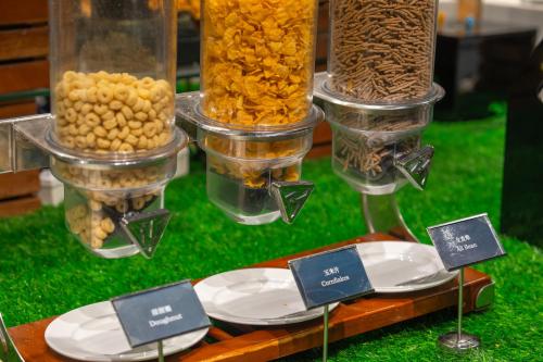a display of food in containers on a table with plates at Castfast Hotel in Dongguan