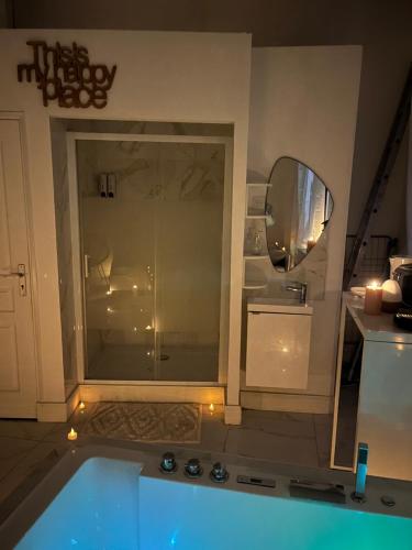 a bathroom with a tub and a shower with a mirror at Love White Room Privée avec Spa privatif in Tourcoing