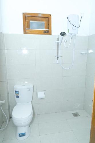 a bathroom with a toilet and a shower at Rika Guest House in Kokkuvil East