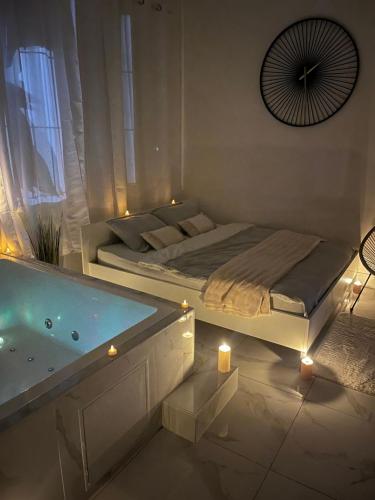 a bedroom with a bed and a bathtub with lights at Love White Room Privée avec Spa privatif in Tourcoing