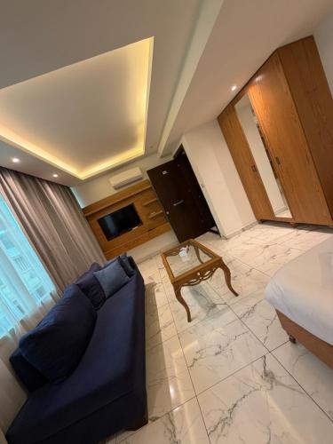 ein Zimmer mit einer Couch, einem Bett und einem Tisch in der Unterkunft Sama AL Hamra Hotel Apartments in Raʼs Bayrūt