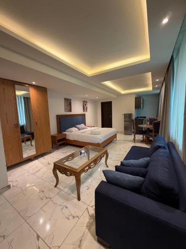 ein großes Wohnzimmer mit einem Bett und einer Couch in der Unterkunft Sama AL Hamra Hotel Apartments in Raʼs Bayrūt