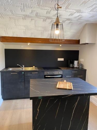 a kitchen with a black counter top and a sink at Sous l'Alpette en Chartreuse in Saint-Pierre-dʼEntremont