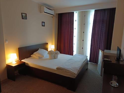 a bedroom with a bed with two lamps on it at Vila KM 0 in Neptun