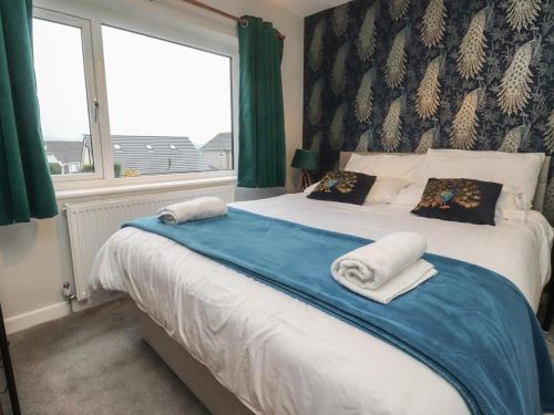 a bedroom with a large bed with towels on it at Thieveley Pike View in Burnley