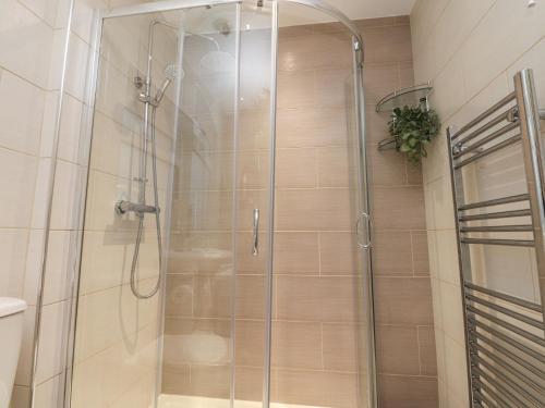 a shower with a glass door in a bathroom at Thieveley Pike View in Burnley