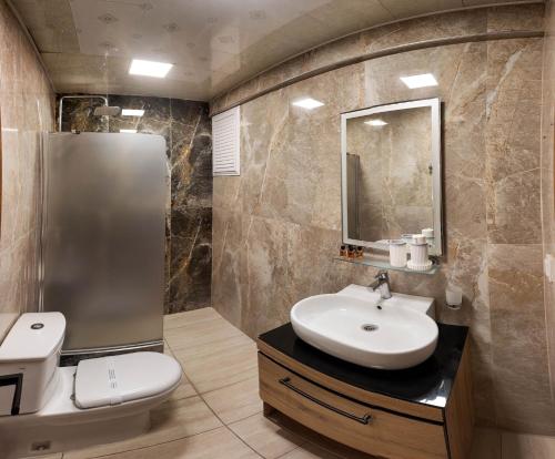 a bathroom with a sink and a toilet and a mirror at Asya Blue Apartments in Marmaris