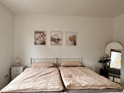 a bedroom with two beds and three pictures on the wall at Schöne Ferienwohnung mit Waldblick in Dillenburg in Dillenburg