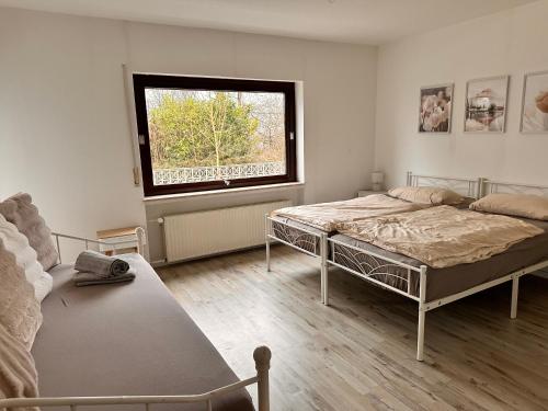 a bedroom with two beds and a window at Schöne Ferienwohnung mit Waldblick in Dillenburg in Dillenburg