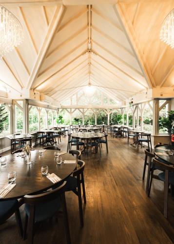 a dining room with tables and chairs in a tent at The Moat House in Stafford