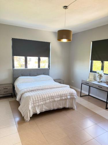 a bedroom with a large bed and two windows at Villa Mauritius in Albion