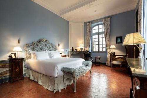 a bedroom with a large white bed and a chair at Château de Collias - Maison de Vacances in Collias