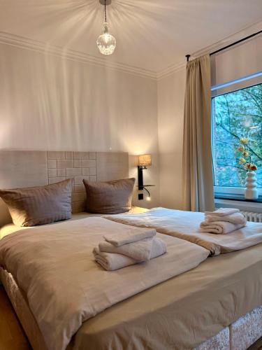 a large bed in a bedroom with a window at Residenz am Pferdemarkt - exklusives Wohnen im Herzen Ostfrieslands - stillvoll & luxuriös in Aurich