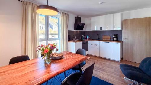 a kitchen with a wooden table with a vase of flowers on it at Ferienwohnung CityVibes in Winterberg