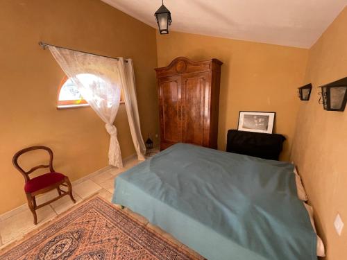 a bedroom with a bed and a chair and a window at La Parenthèse ardéchoise - Spa et billard - Se ressourcer entre ville et forêt in Privas