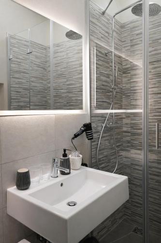 a bathroom with a white sink and a shower at LA CASA DI TALIN - Camere e appartamenti - Accoglienza adults only in Serravalle delle Langhe
