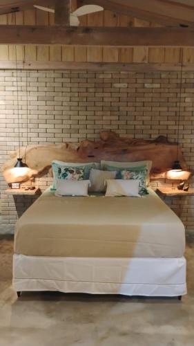 a bedroom with a large bed with a wooden headboard at Doce inga in Cairu